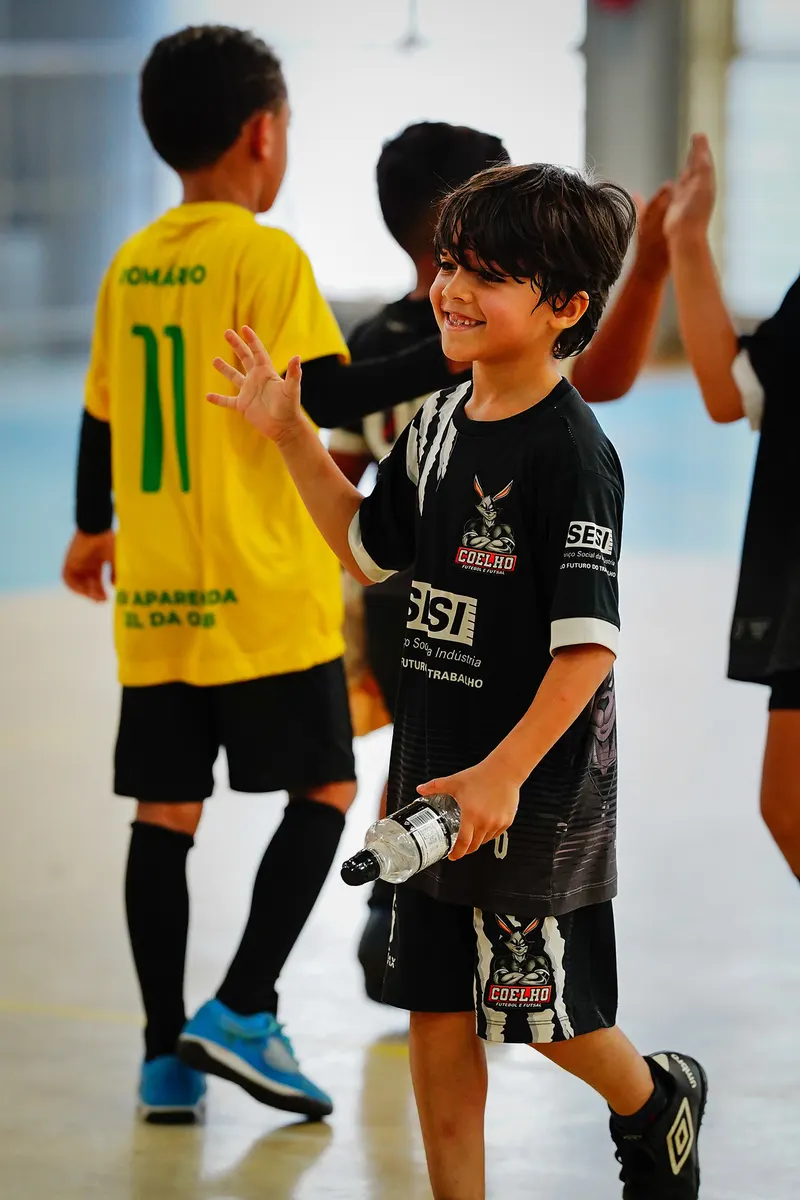Alunos rindo e comemorando na quadra